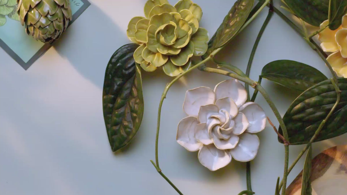 A top-down pan across English Garden ceramic flowers styled with monstera leaves — english garden style in hand-glazed ceramic.
